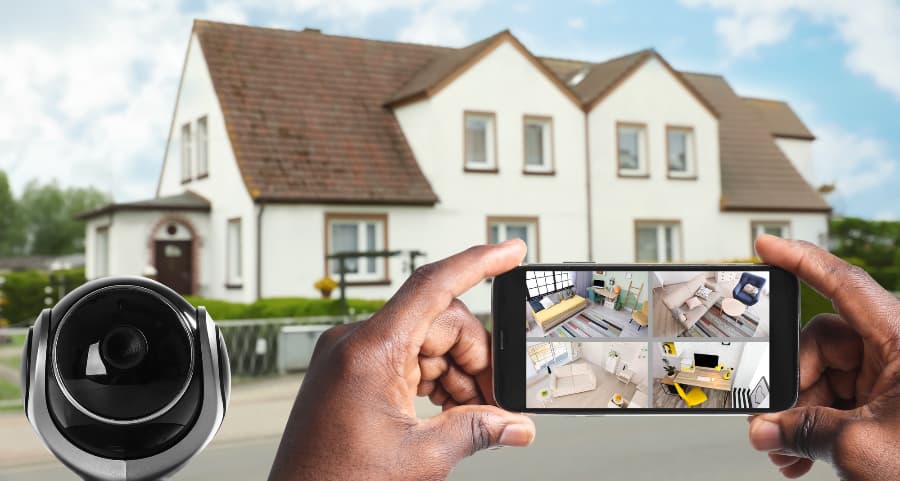 Man holding smartphone and checking footage from surveillance cameras